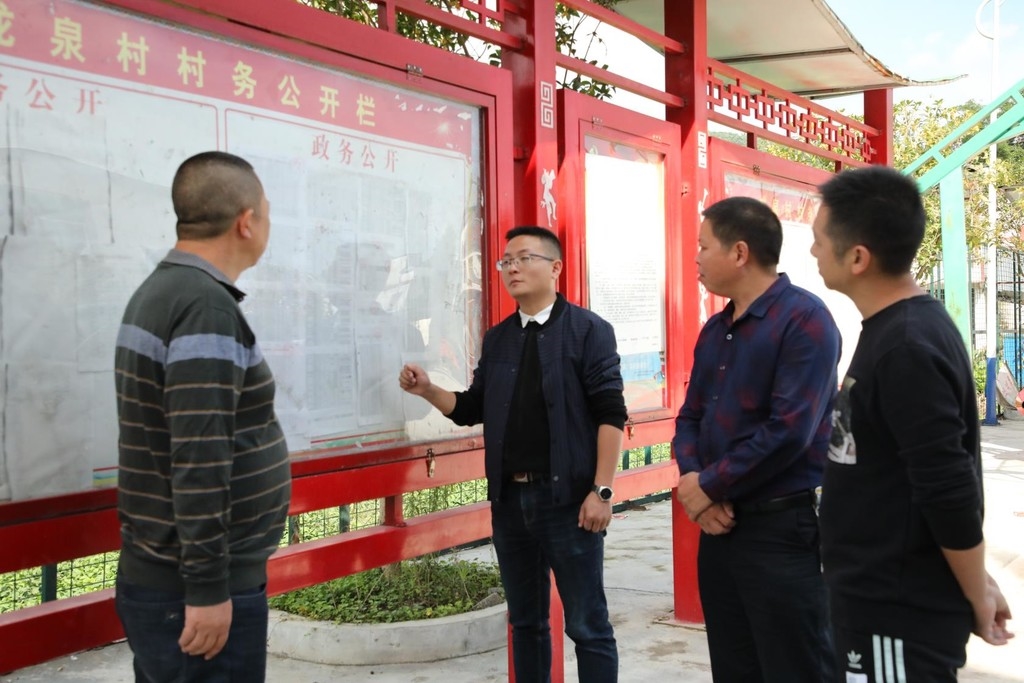 兴文县麒麟苗族乡纪委书记在龙泉村查看村务公开工作. 兴文县纪委供图