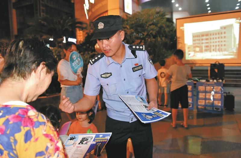 图为29日,李国伦利用放映法治片的机会向群众发放扫黑除恶宣传资料