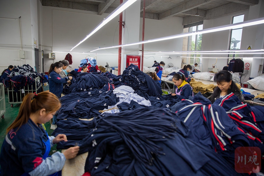 广安市广安区官盛新区服装厂的留守女工正在整理成衣.
