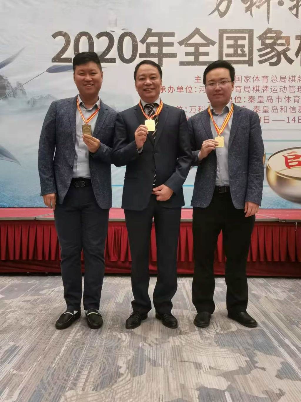 夺冠后,教练李艾东(中)与川军两大棋星郑惟桐(右),孟辰(左)合影.