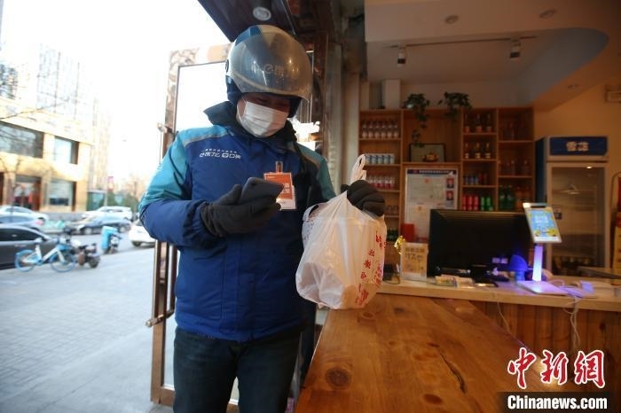 资料图：“饿了么”外卖员正在取餐。　张云 摄