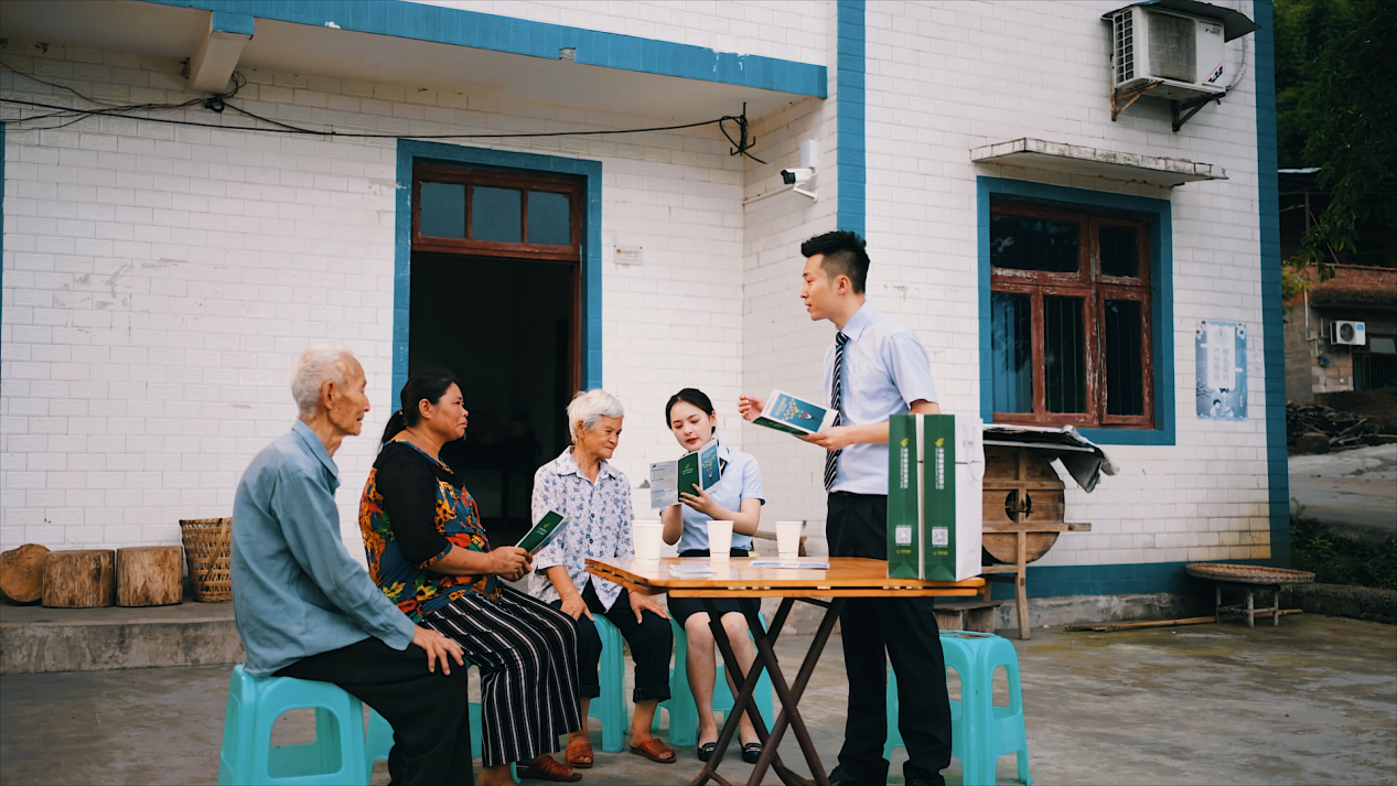 邮储银行重庆分行供图-图为邮储银行工作人员挨村入户为村民普及金融知识