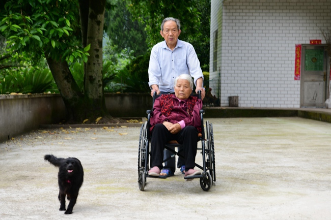晏四和推着轮椅，让妻子在院子里呼吸新鲜空气。彭杰摄